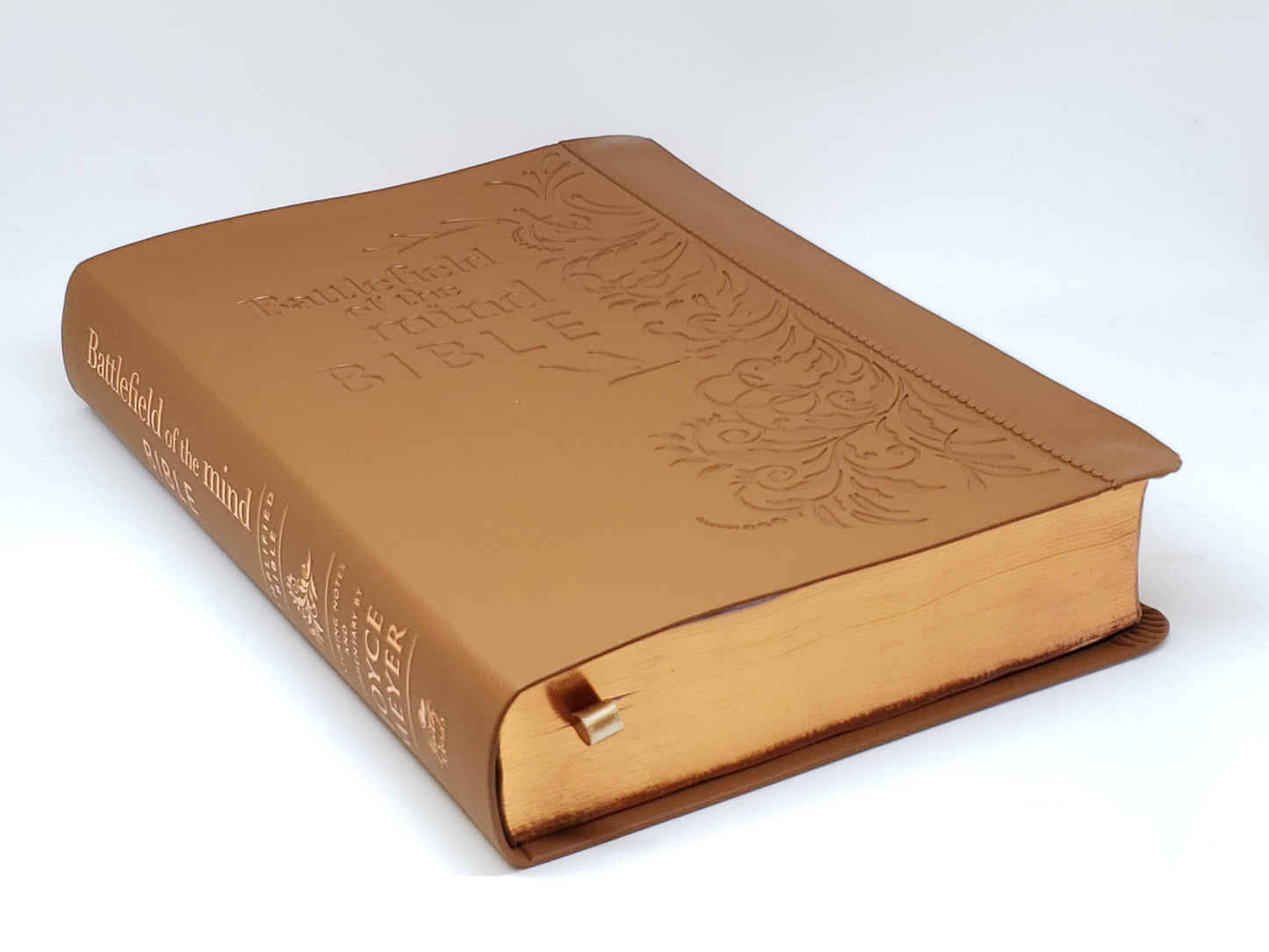 Brown leather-bound book with embossed text on a white background